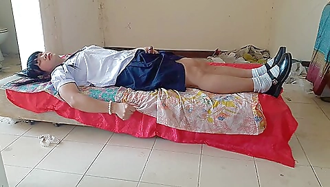 Asian teen in school uniform plays with herself in the playground